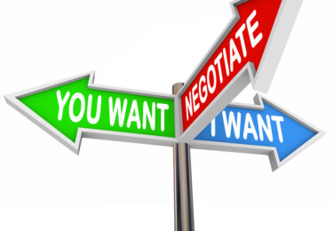 Coming to an agreement through negotiation illustrated by three road or street signs with the words You Want, I Want, Negotiate