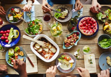 People having a rich dinner with fresh vegetables and homemade meal